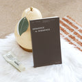 Dark ‘Sequence to Sequence’ weekly time planner standing upright on a board covered with white fabric