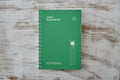 deep green Lucky Study Planner with spiral binding and a subtle clover illustration on a grid pattern.